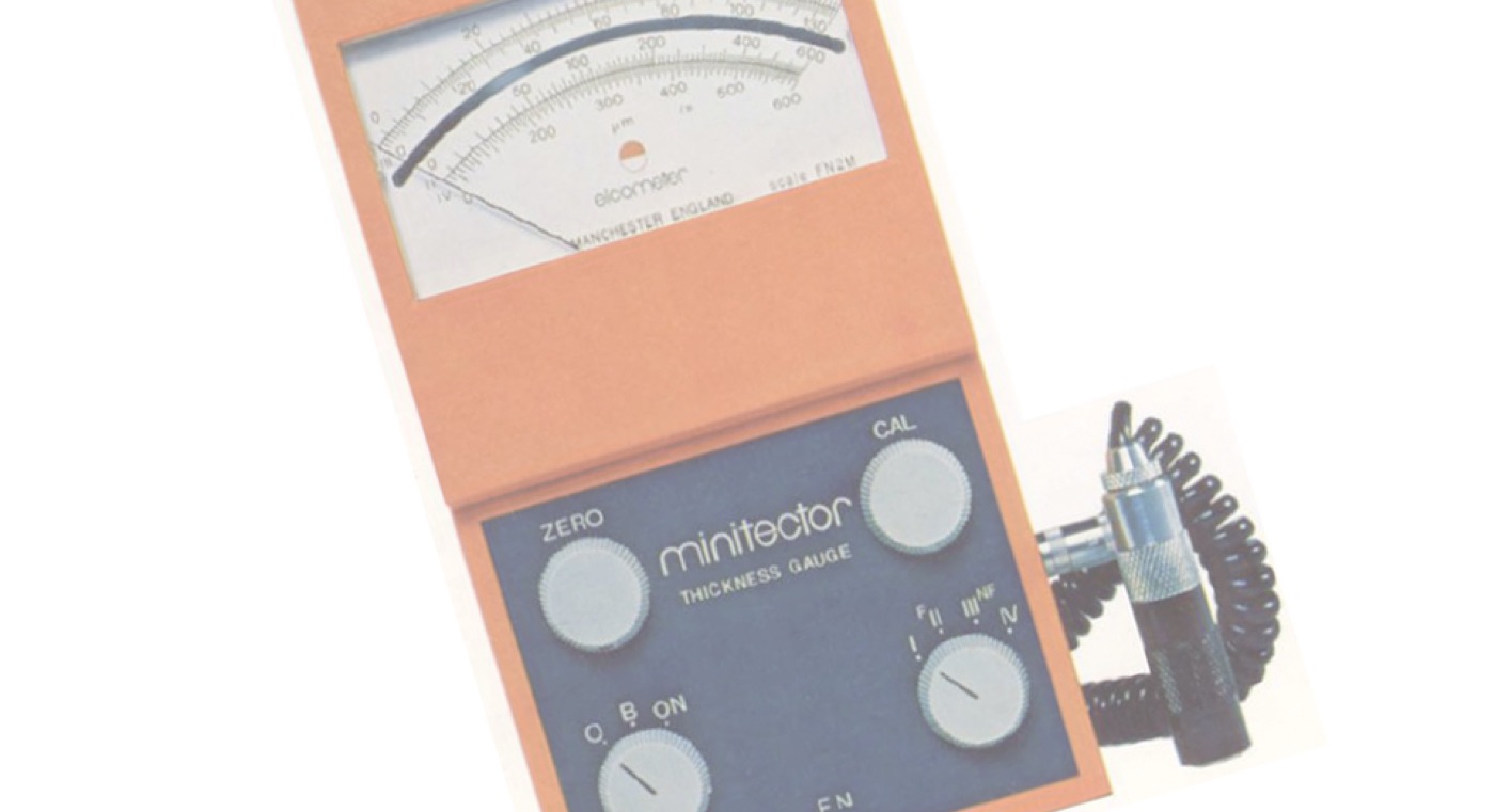 An Elcometer Minitector thickness gauge with fold-out analogue dial and coiled probe lead
