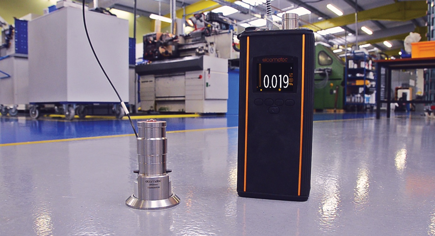 An Elcometer 510 automatic pull-off adhesion tester with a 50mm dolly on a coated floor