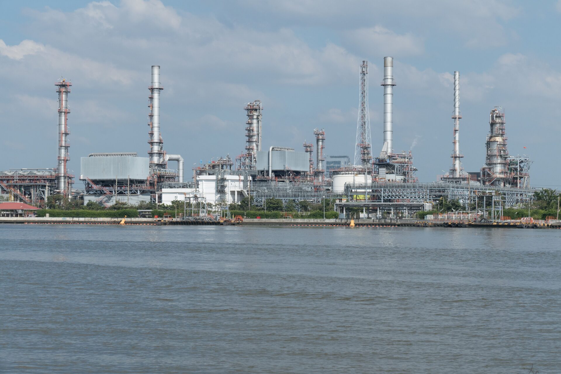 Coastal oil refinery with distillation columns and storage tanks under coating and corrosion inspection